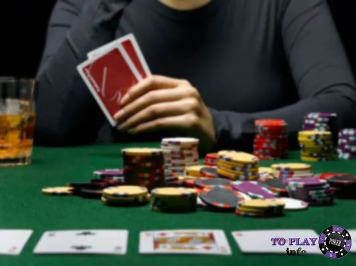 Poker player holding cards with large stack of chips – high stakes poker concept